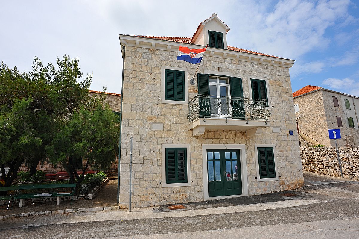 Das Apartmenthaus in Sutivan: heller Steinbau mit grünen Fensterläden und kroatischer Flagge